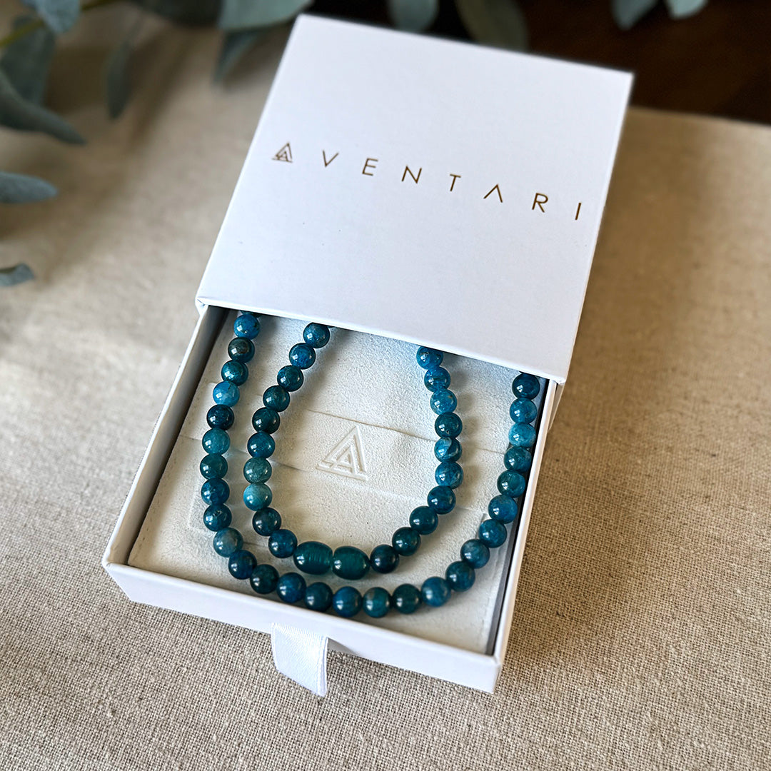 Blue-green Aventari Apatite Focus Necklace presented inside its white branded gift box for clarity and intellect.