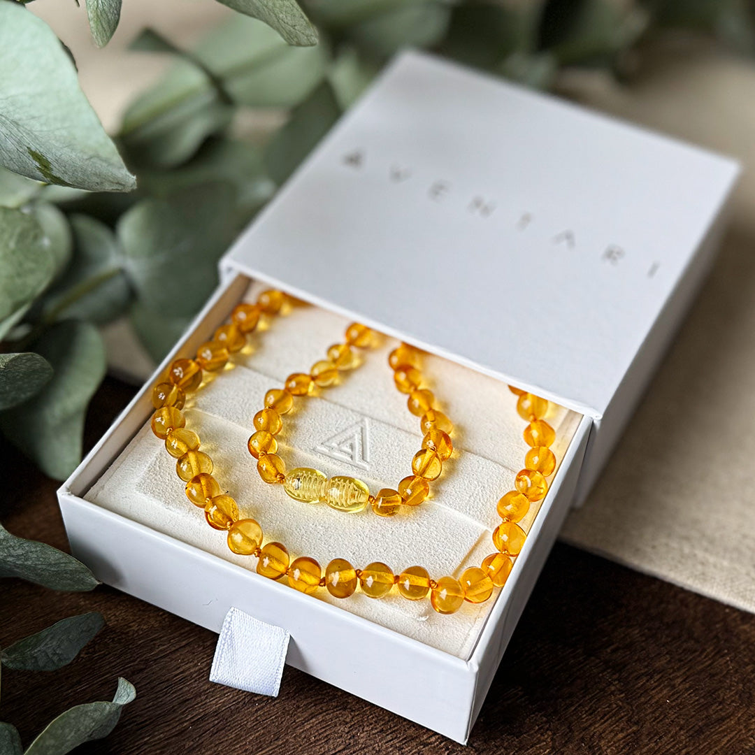 The Baltic Amber Soothing Necklace presented elegantly inside its white Aventari branded gift box, showcasing the quality packaging.