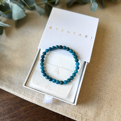 Blue-green Aventari Apatite Bracelet for focus and intellect presented inside its white branded gift box.