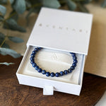 Deep blue Aventari Lapis Lazuli Protection Bracelet displayed in its white branded gift box.