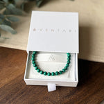 The green banded Malachite Transformation Bracelet by Aventari displayed inside its white branded gift box.